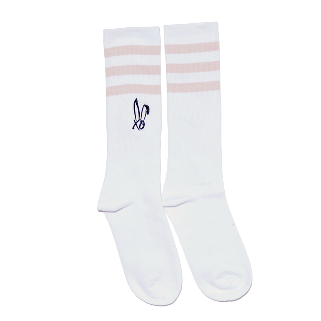 Classic white tube socks with pink stripes and the Bunnie Xo logo in black on the sides. 
