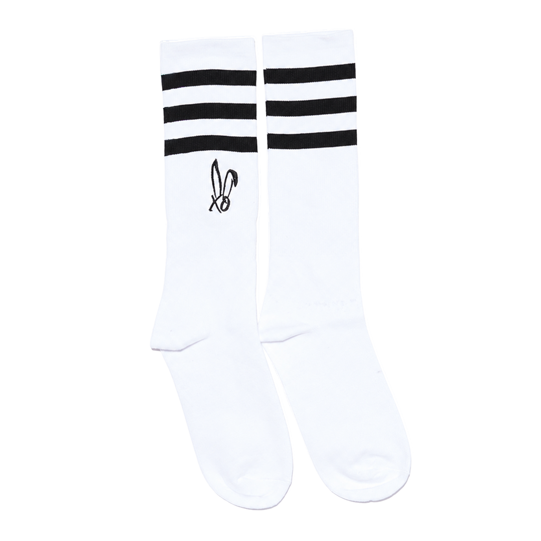 Classic white tube socks with black stripes and the Bunnie Xo logo in black on the sides. 